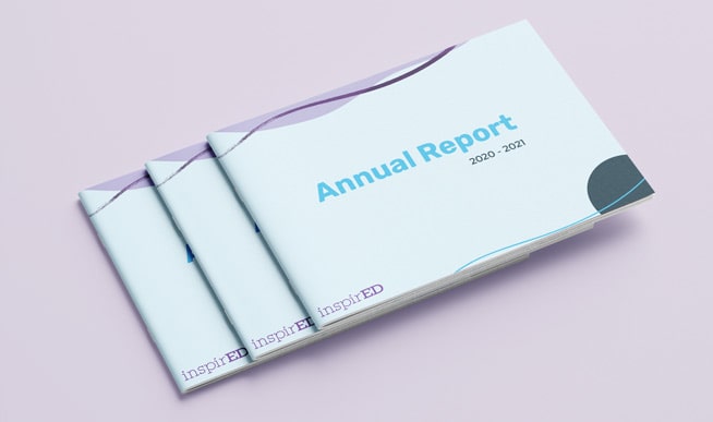 Annual Report booklets stacked on top of each other.